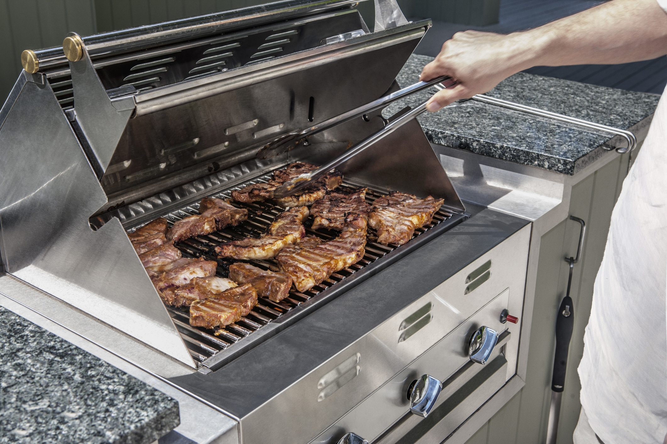 User cooking beef steaks on a gas fuel grill