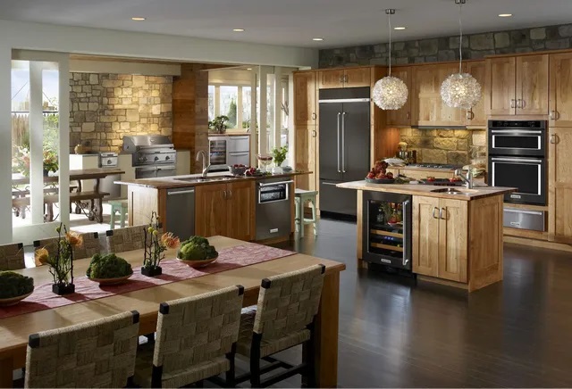 Warm-toned kitchen with natural wood cabinetry and a KitchenAid suite of appliances
