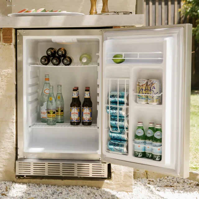The Coyote CBIR-R outdoor refrigerator with its door open full of beverages 