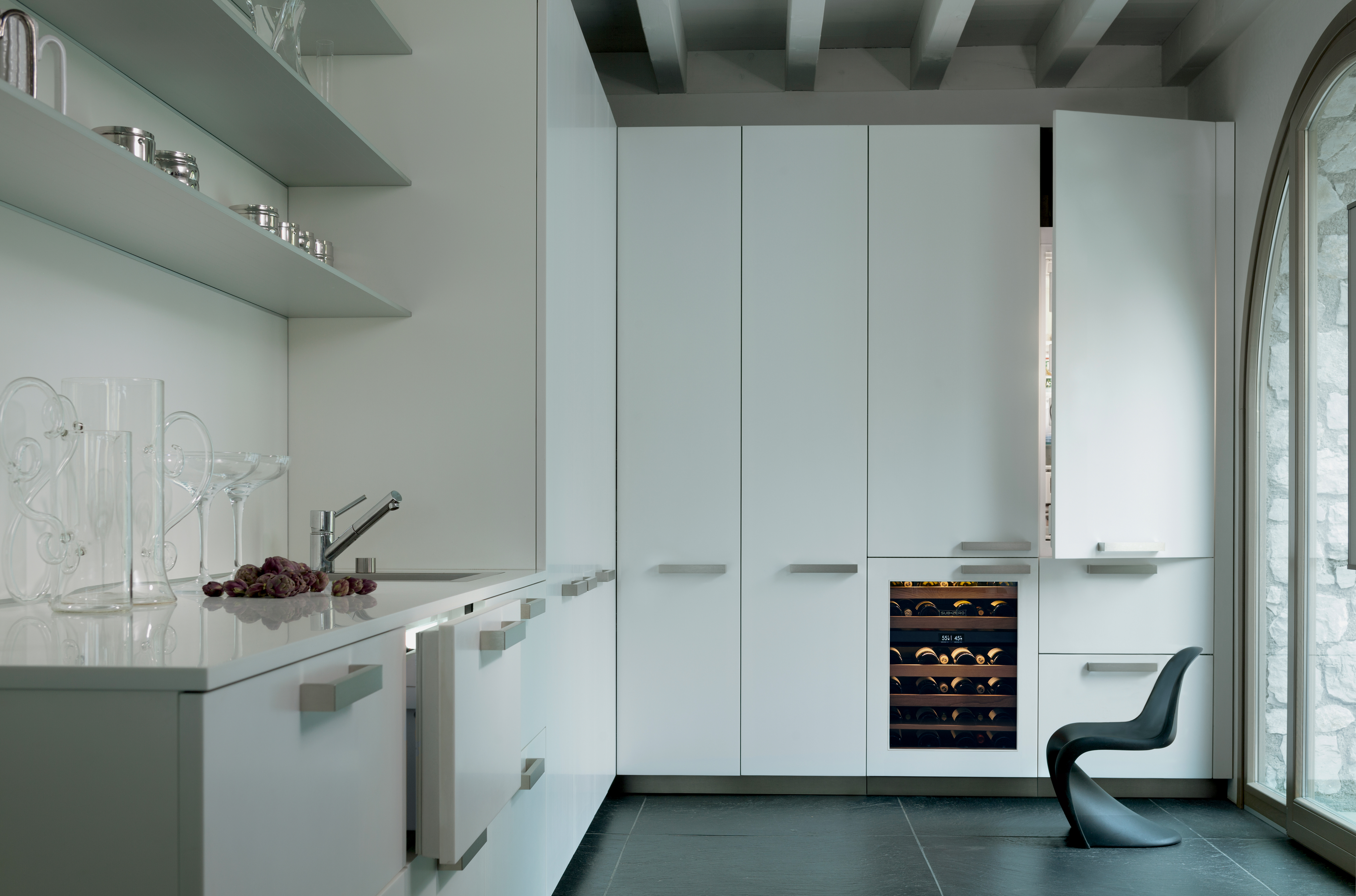 all white high end kitchen full of sub zero refrigerators in various configurations