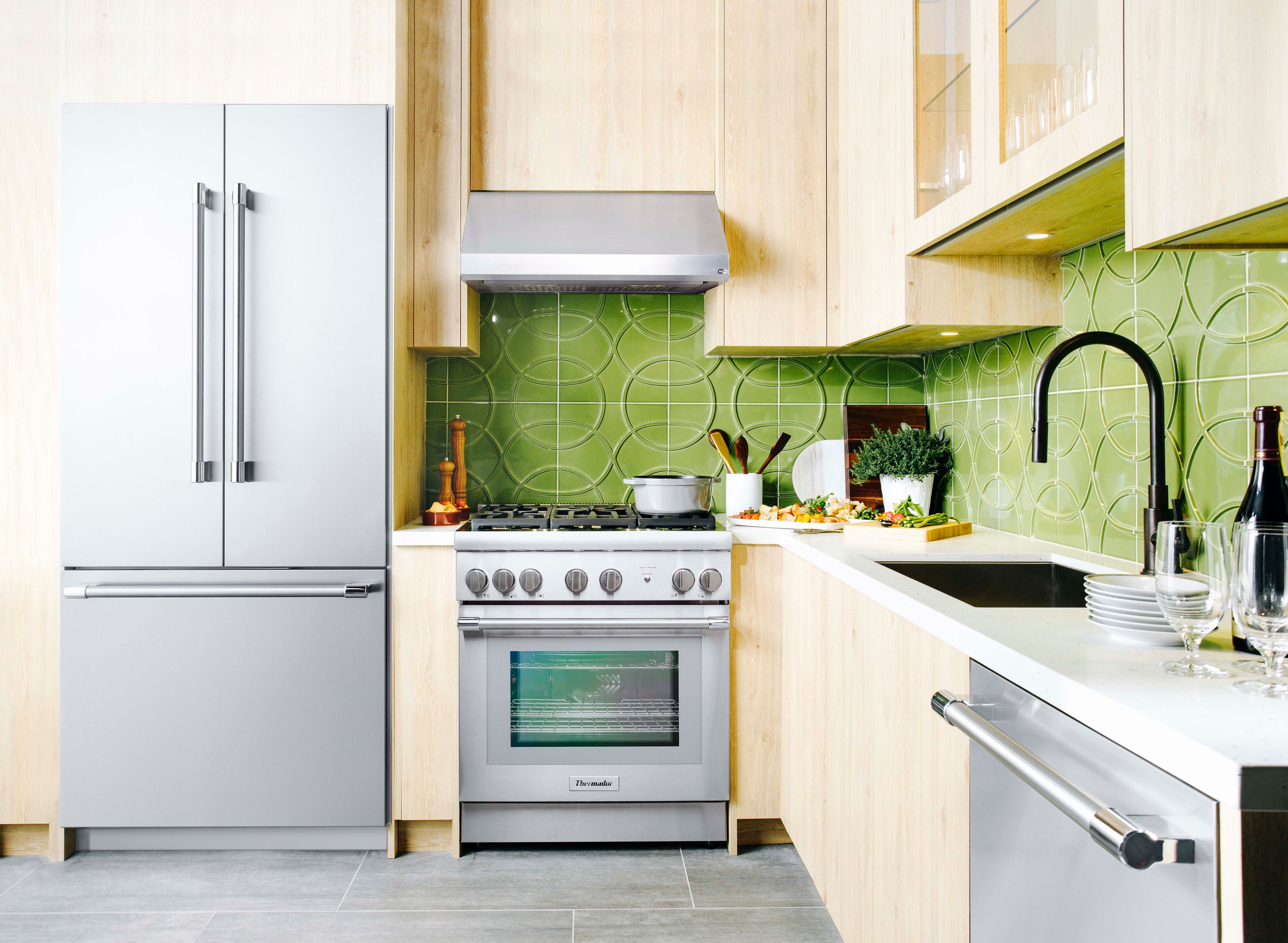 Wide shot of green-themed kitchen with a full suite of Thermador appliances 