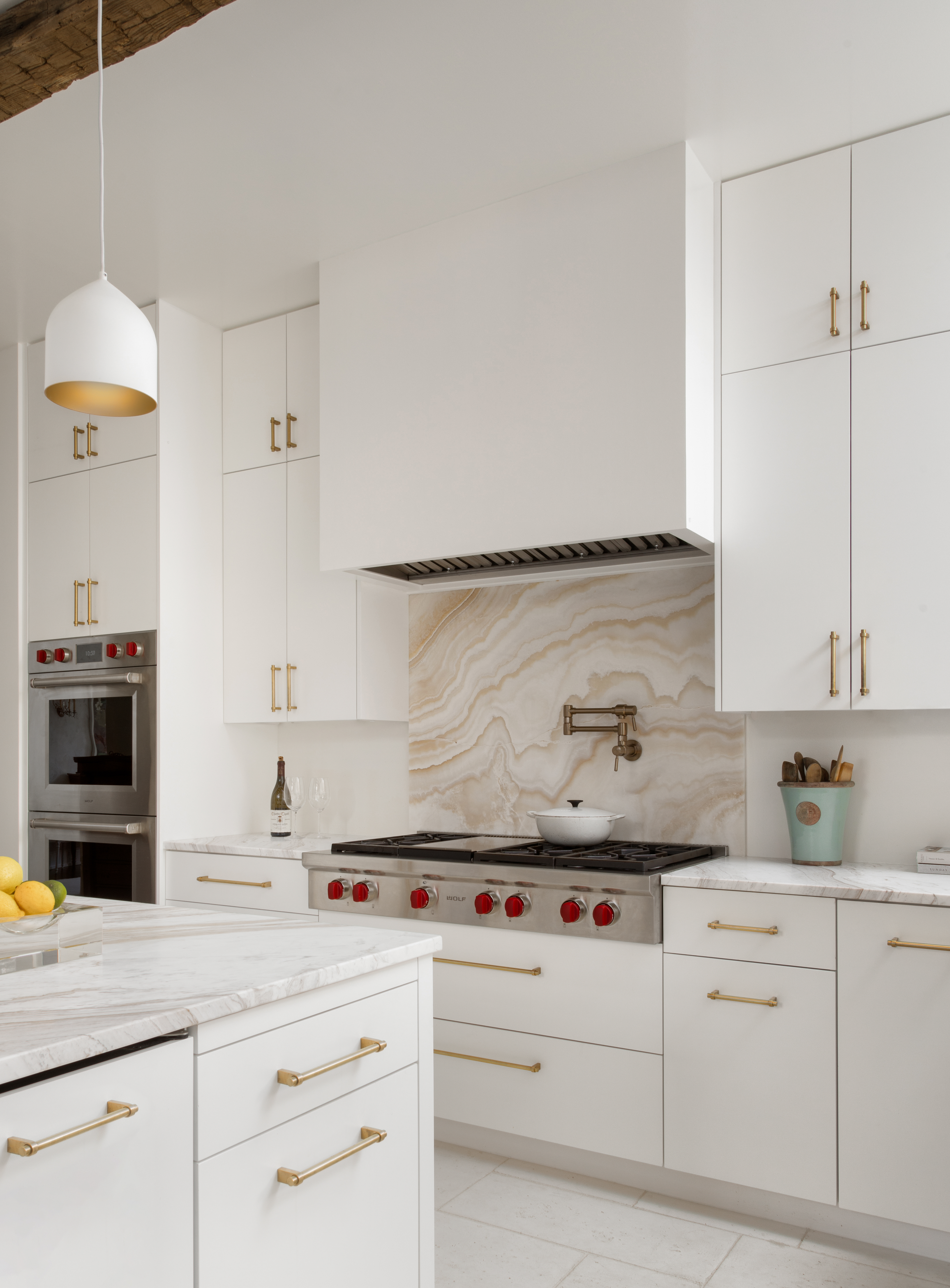 modern white kitchen featuring wolf rangetop and double wall oven 