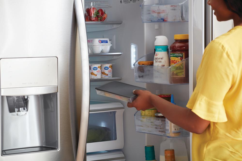 woman organizes Frigidaire stainless steel French door refrigerator