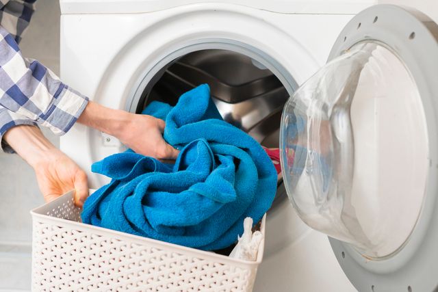 front view of a person loading a front load washer