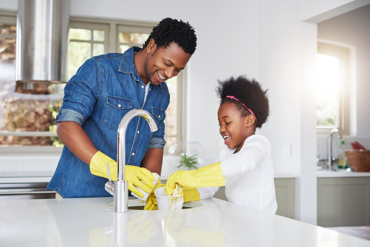 little girl and her father enjoying the kitchen cleanup at home
