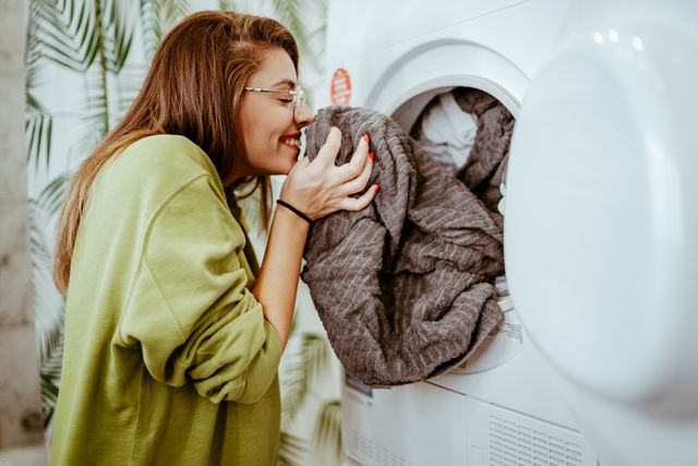 View of a woman smelling a towel and smiling 