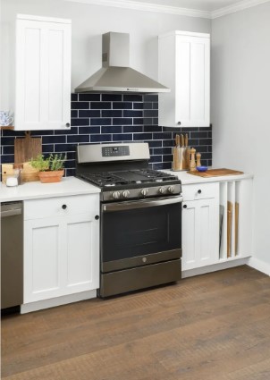 GE gas range in a modern kitchen with white cabinets