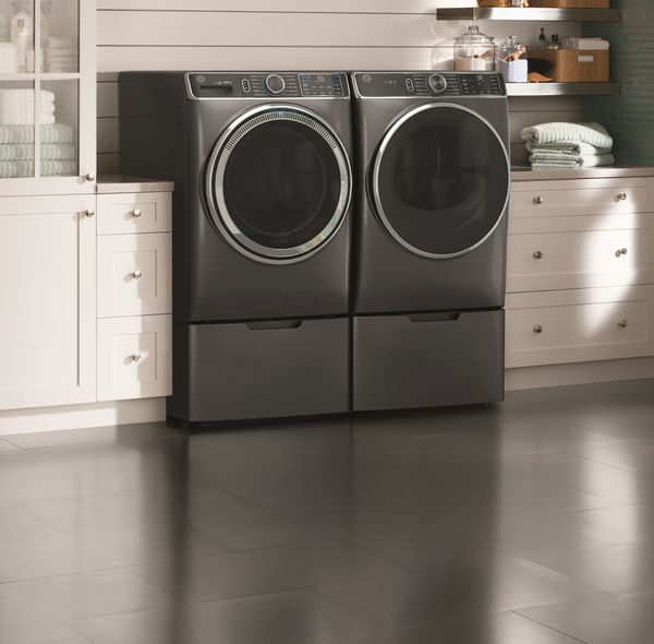 A front view of a GE front load washer and dryer pair in a laundry room