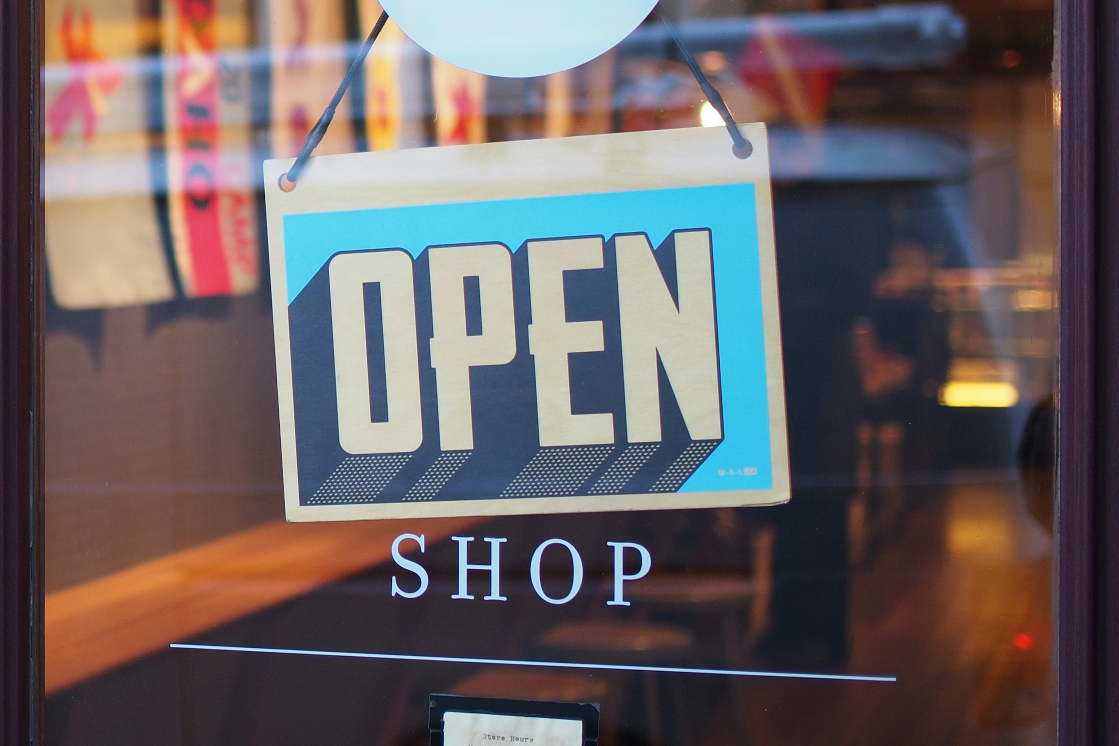 An Open store sign handing on a door 