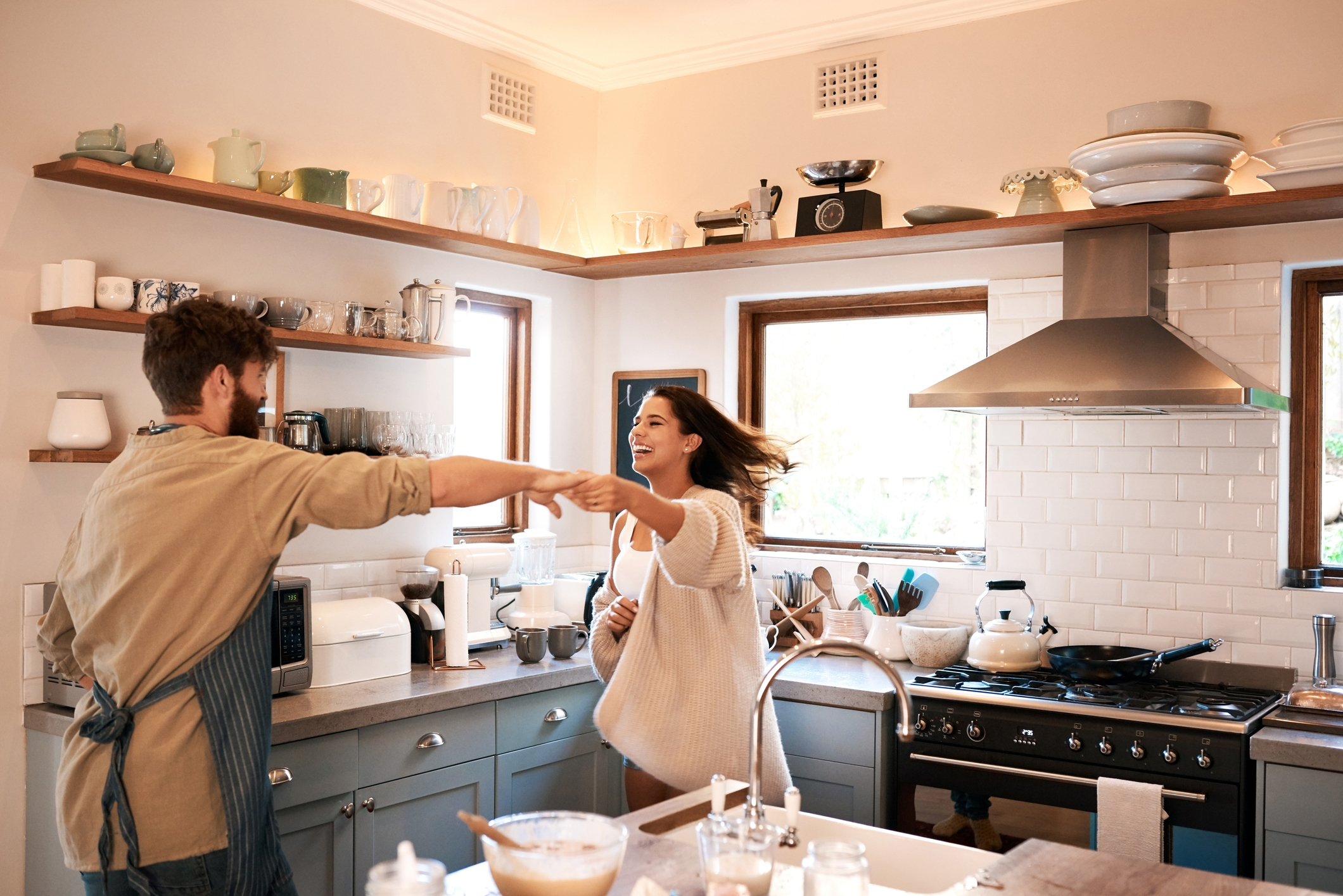 young couple dancing together in the kitchen