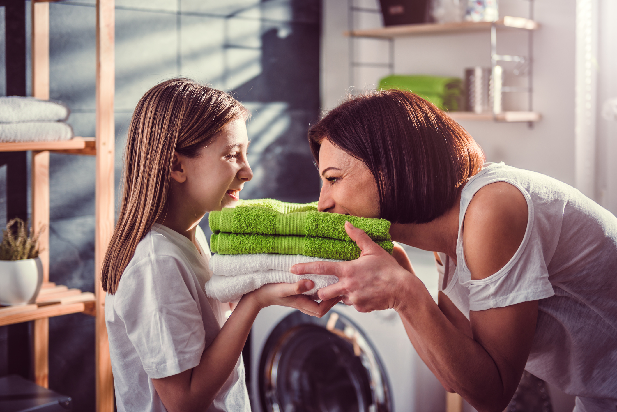 mother and daughter smell fresh folded laundry