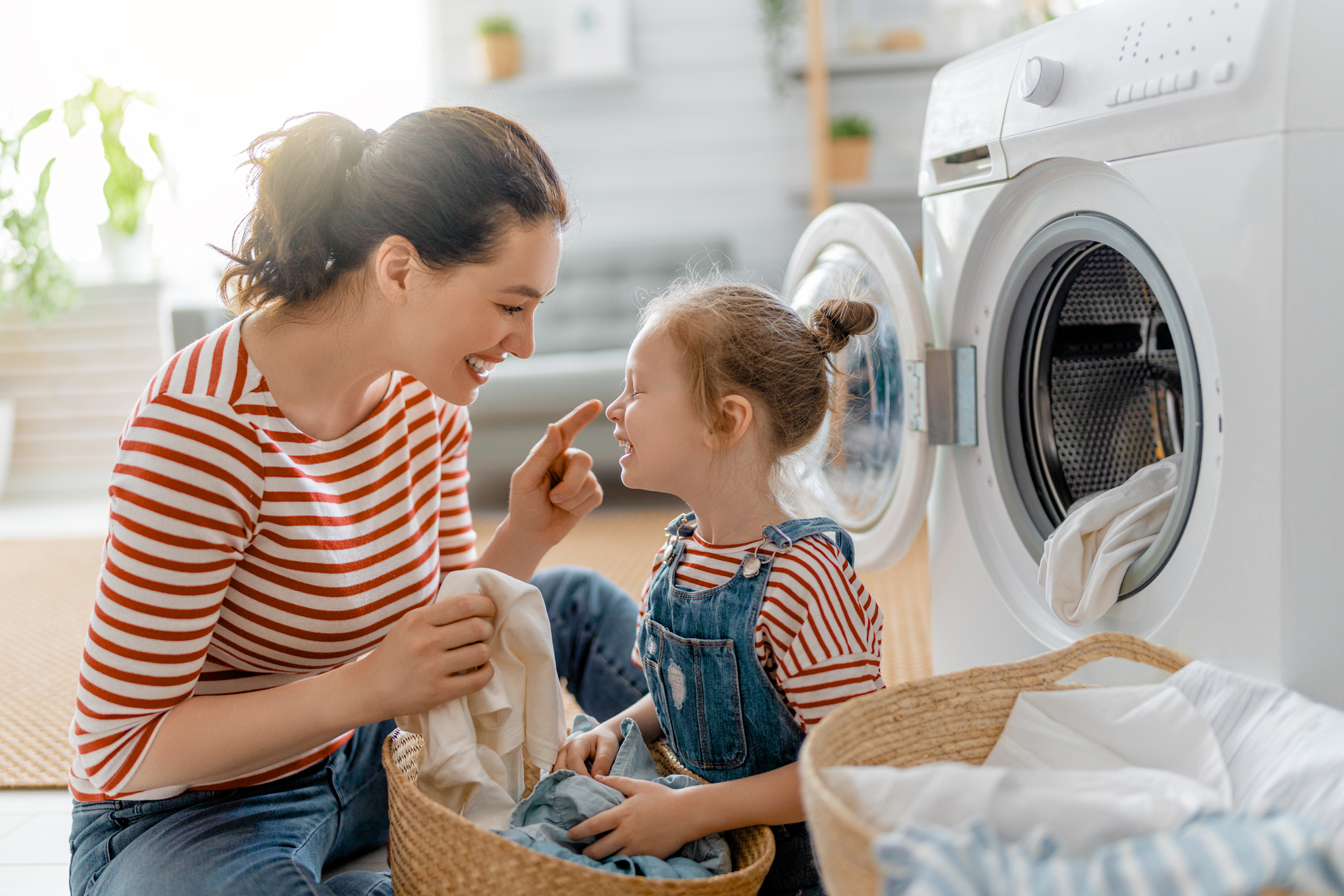 mother and daughter doing laundry together 