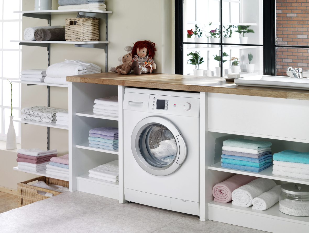 streamlined laundry room featuring a cabinet with open shelves