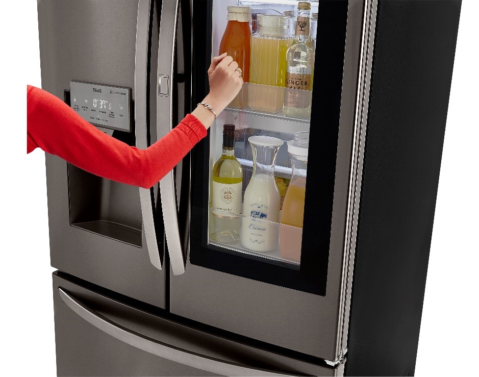 LG product image of woman using the French door refrigerator LFXS26596D InstaView™ Door-in-Door® feature