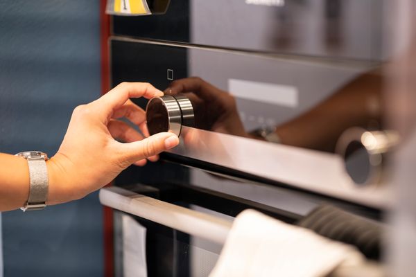 A person selecting the setting on an oven 