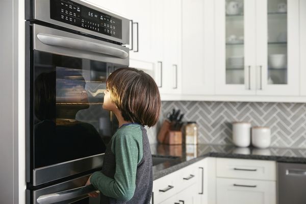 A young boy looking into a Frigidaire Gallery wall oven 