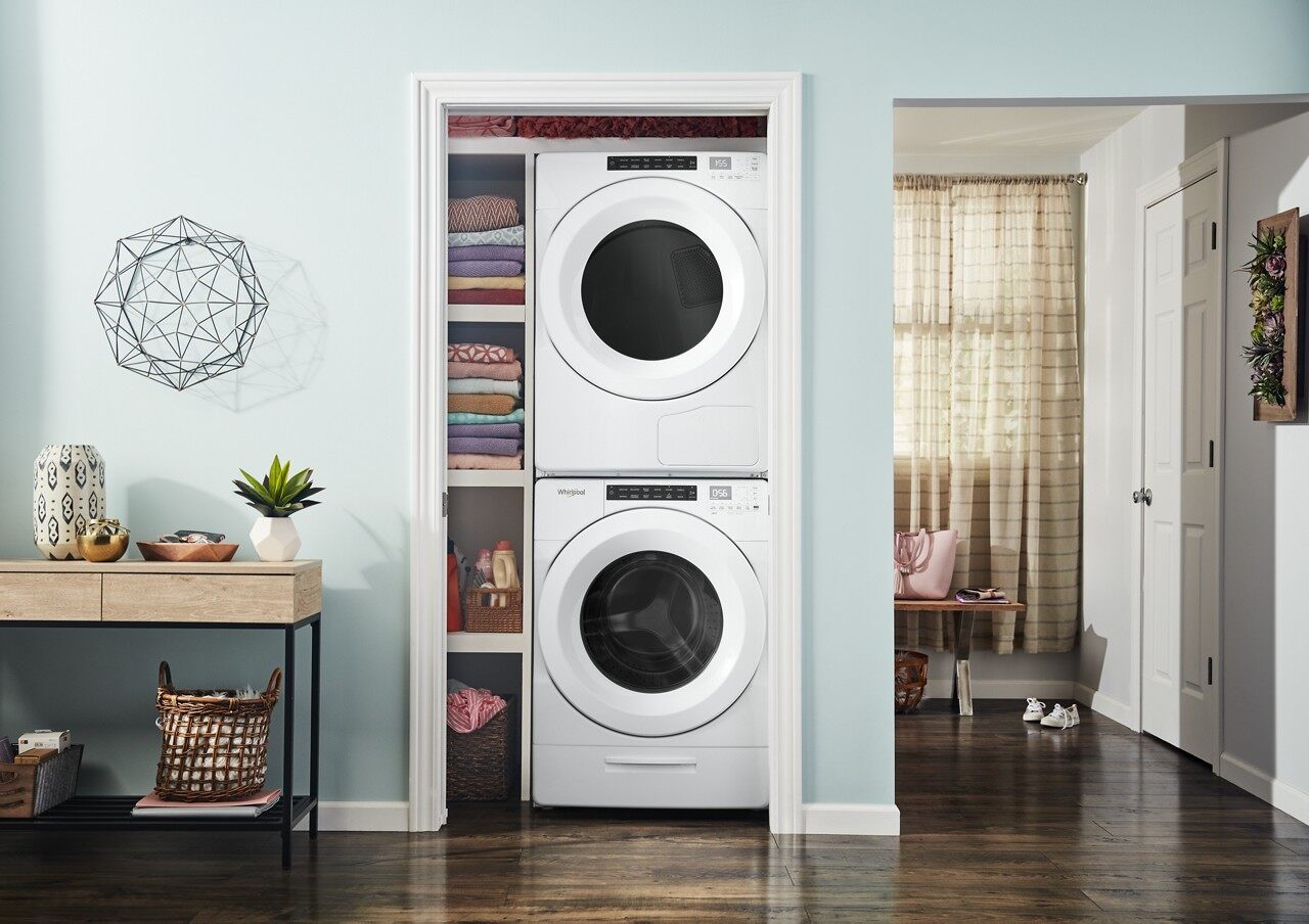 A Whirlpool front load stacked washer and dryer showing installed in a closet 