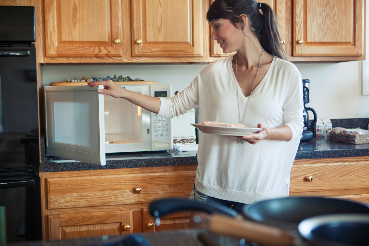 woman cooking in the kitchen, using microwave