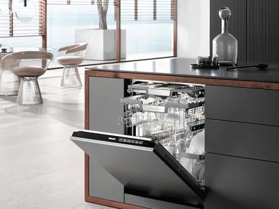 A Miele dishwasher open in a luxury kitche