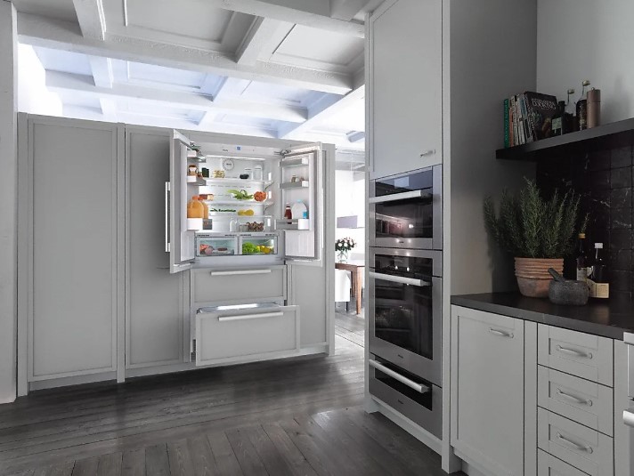 Miele French door refrigerator in a kitchen with all of its doors and drawers open