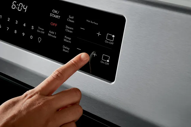 A person selecting a cooking mode on a Frigidaire induction range