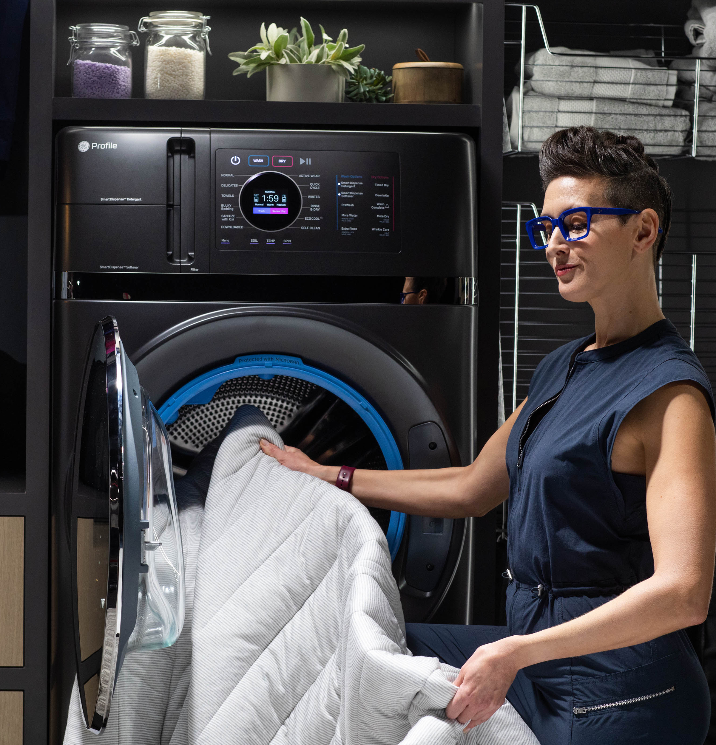 A woman removing a comforter from the GE Profile UltraFast washer dryer combo 