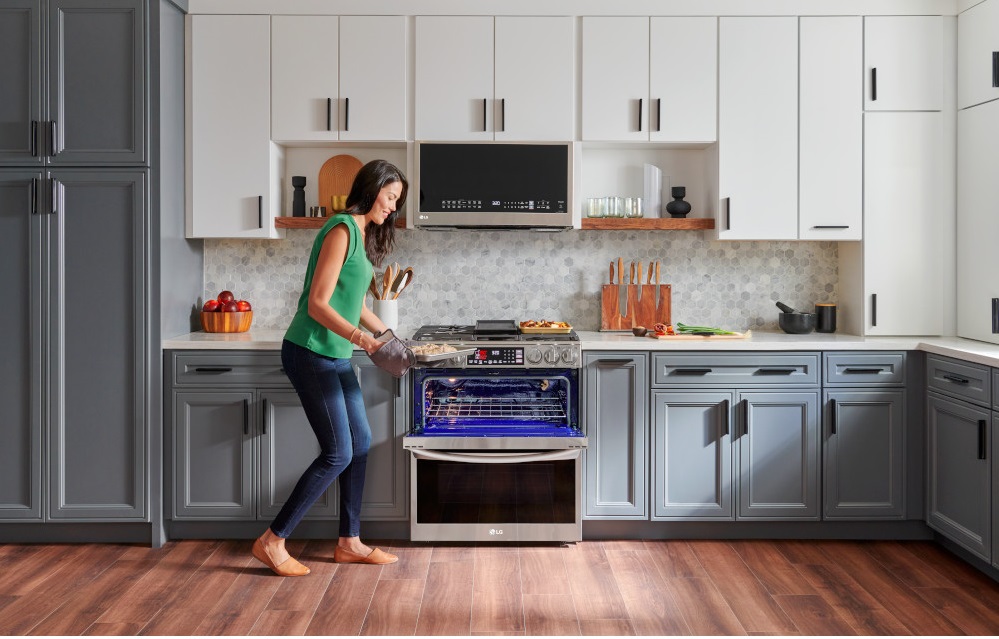  A woman using an LG double oven range 