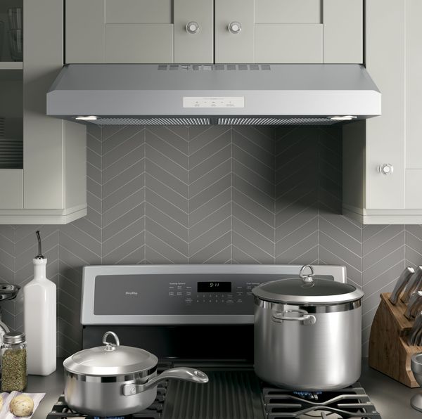close view of a range hood above cooktop in a modern kitchen