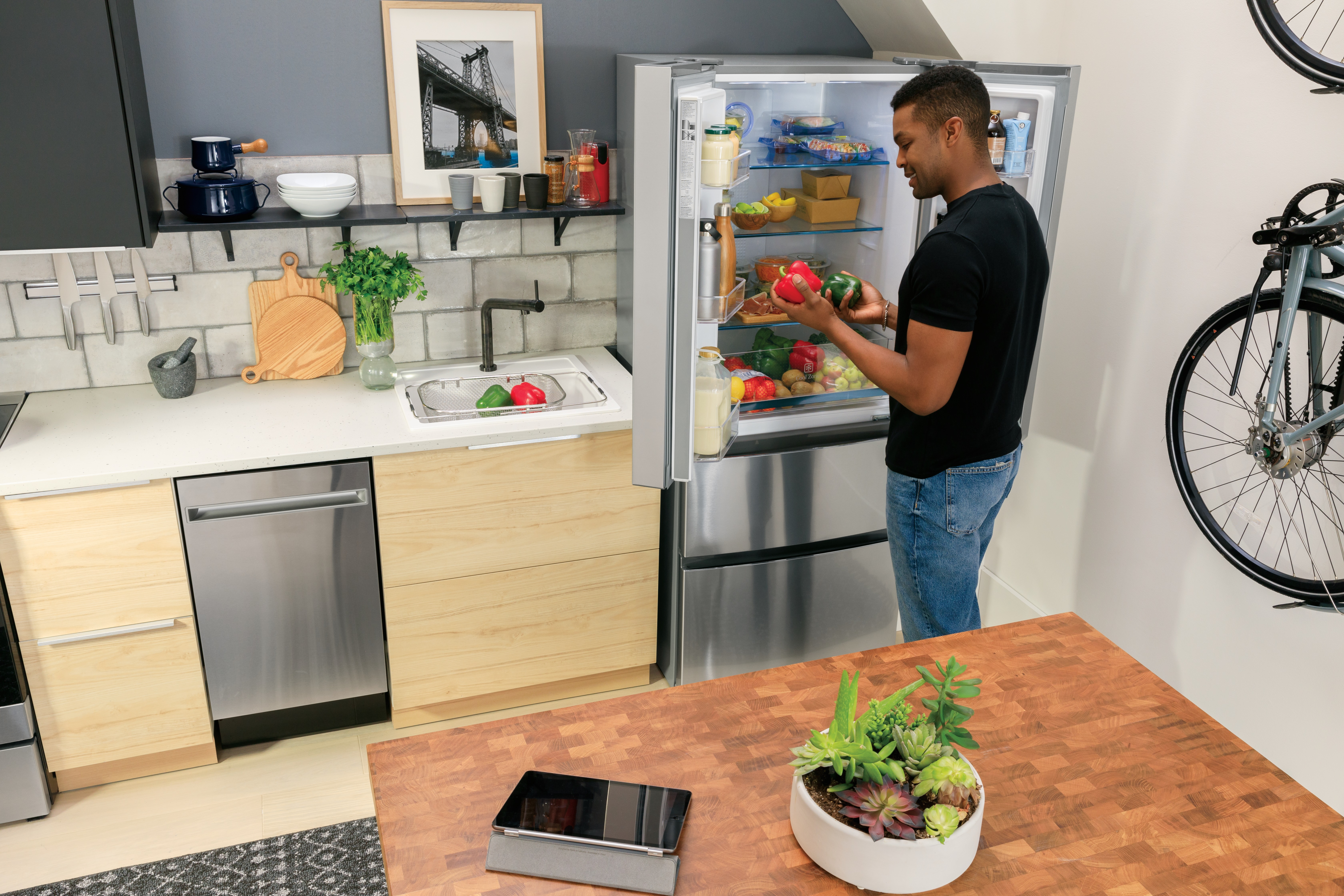 young man peruses contents of compact French door refrigerator