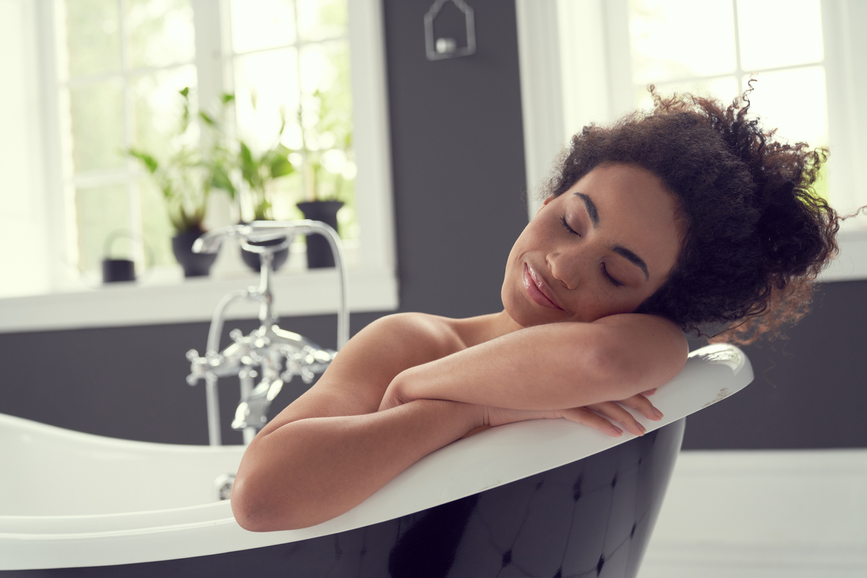 young woman looks serene as she enjoys a bath