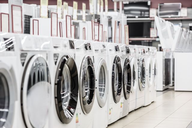 view of an aisle of washing machines on sale in an appliance store