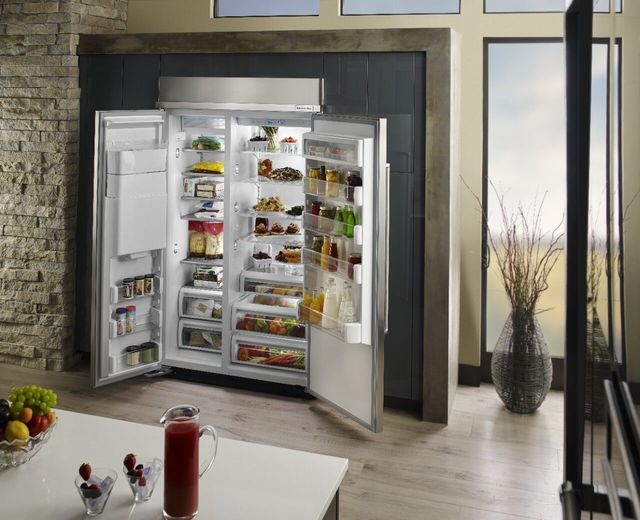 Front view of a modern kitchen with an opened Sside by side refrigerator