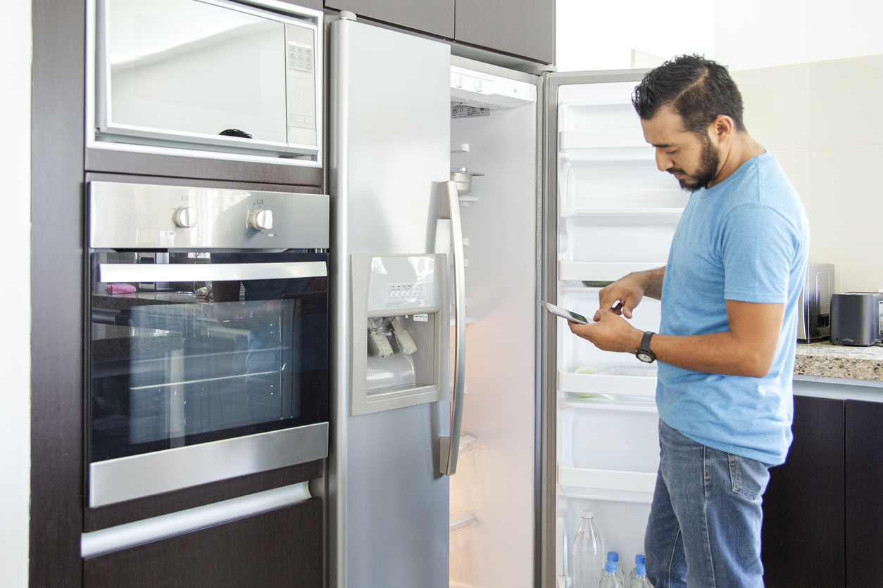 A man browses Black Friday deals while he lingers by his old refrigerator