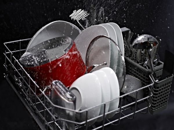 The inside of a KitchenAid dishwasher with dishes 