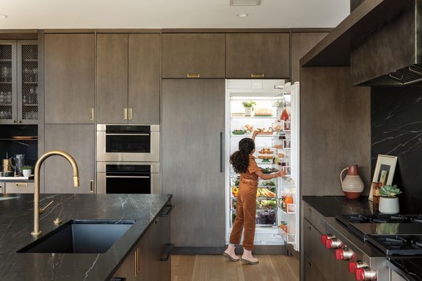 A young girl inside a kitchen featuring Sub-Zero, Wolf, and Cove appliances
