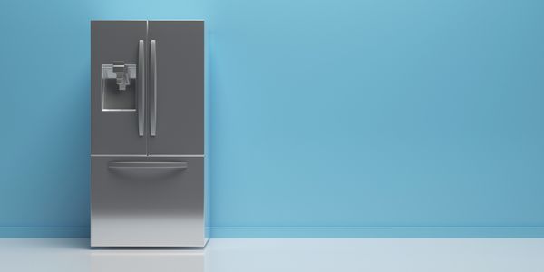 A stainless steel refrigerator against a blue wall 