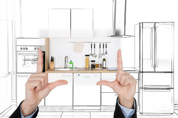 A person holding hands up against a graphic of a kitchen blueprint 