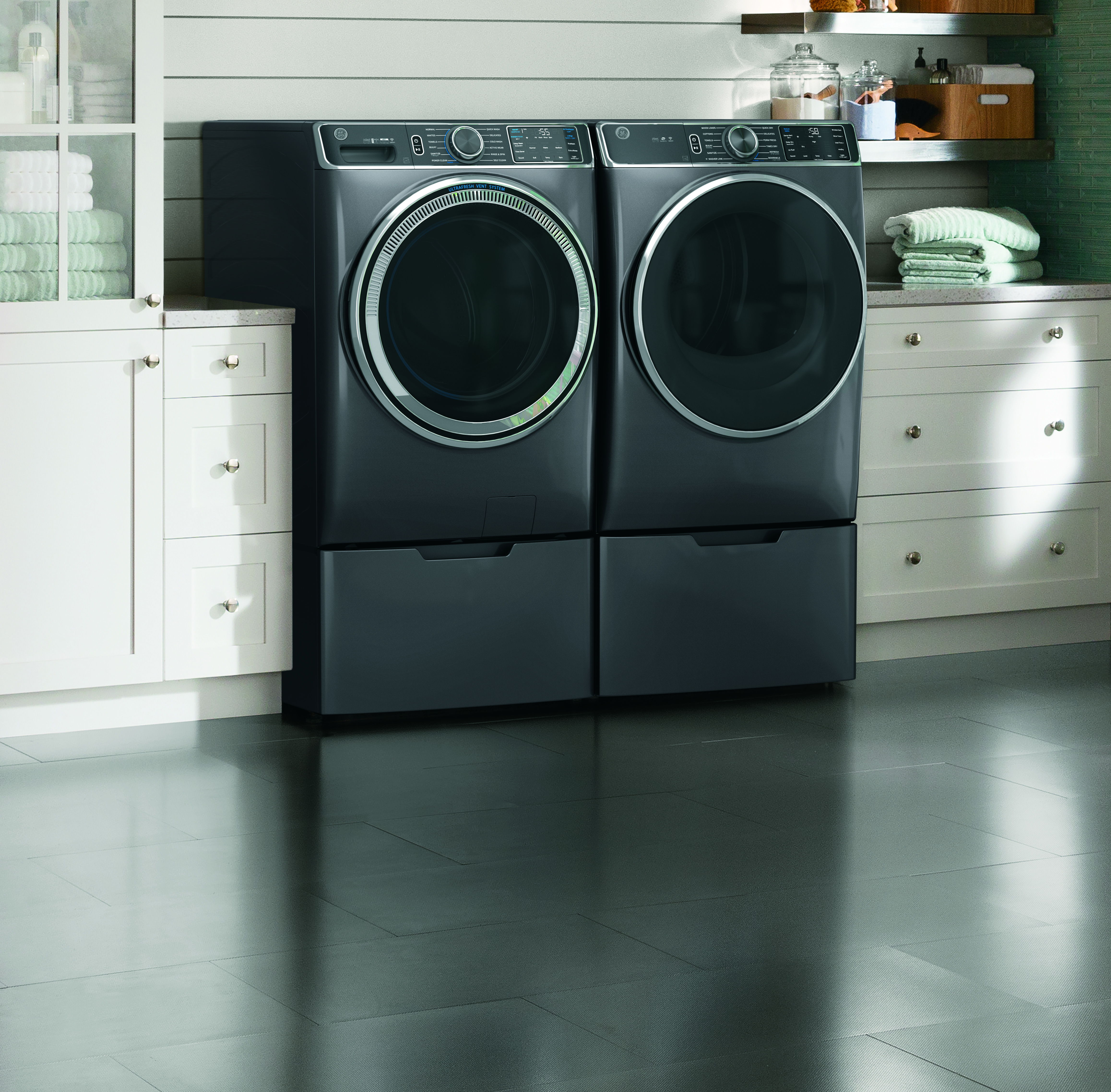 A matching GE front load washer and dryer in a laundry room 