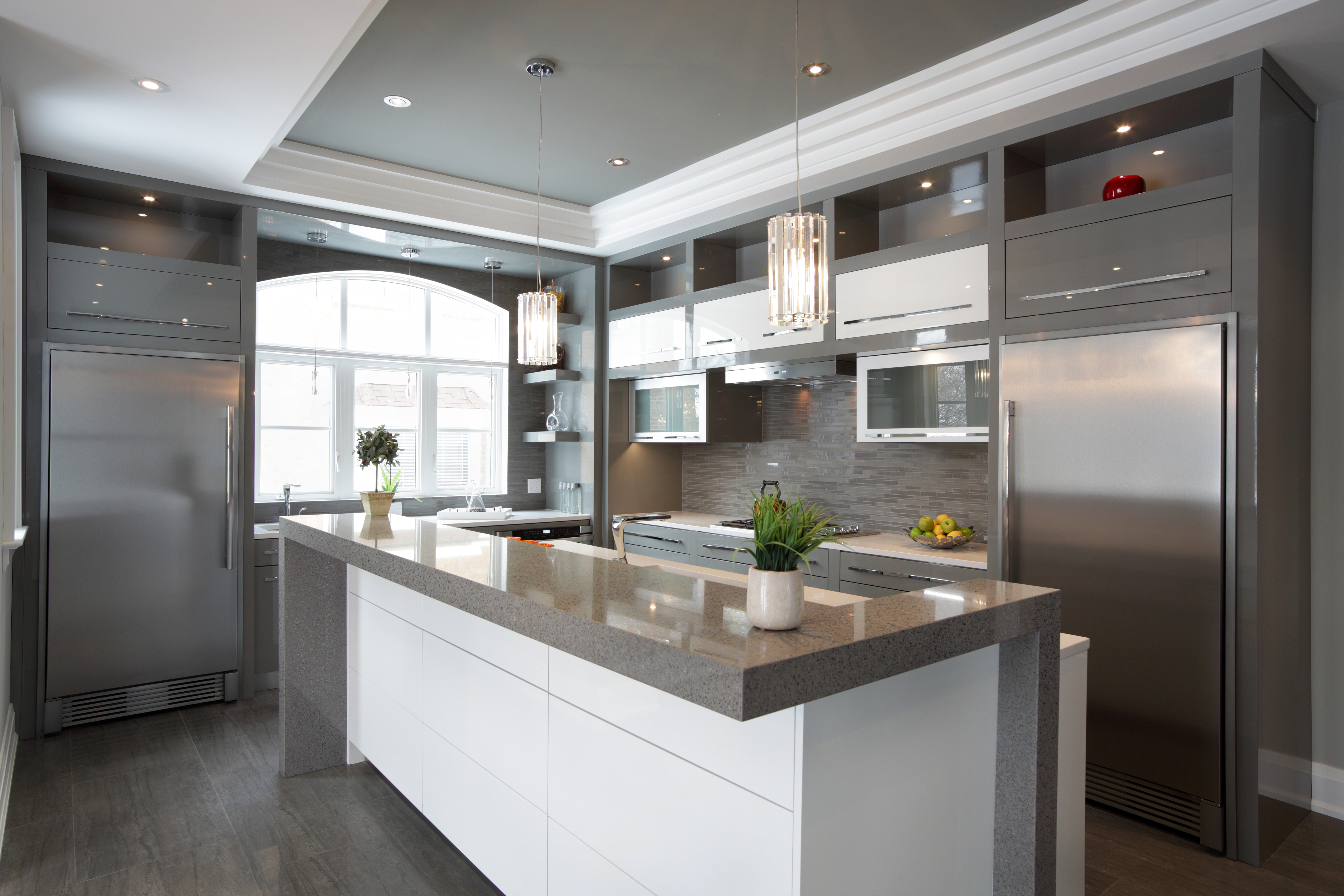 Kitchen with built-in refrigerators, white cabinets, and granite countertops