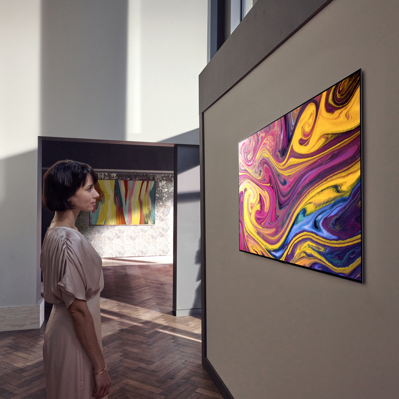 Woman viewing a multicolor pattern on an LG TV with OLED evo technology 