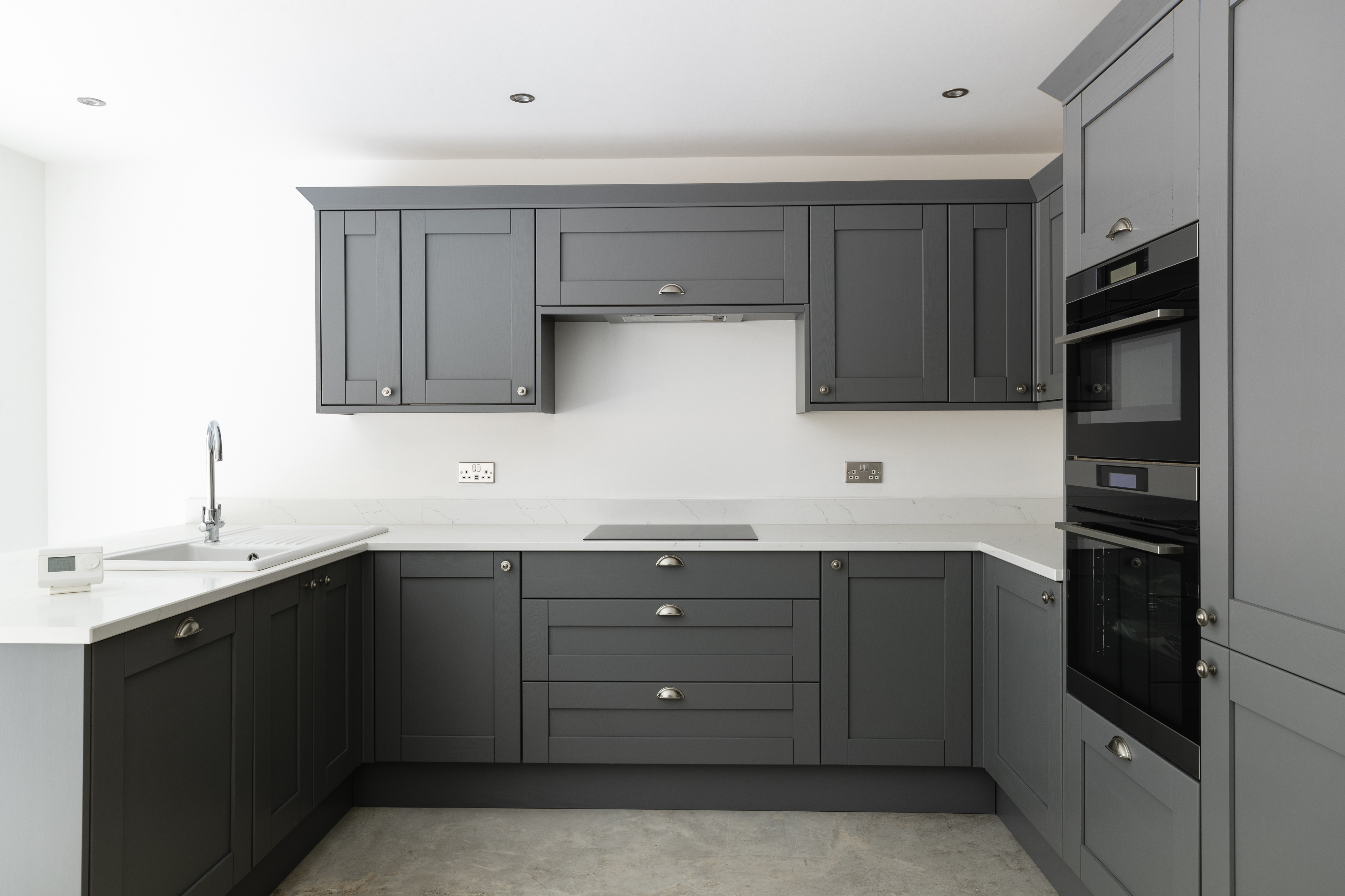 A kitchen with matte gray cabinets 