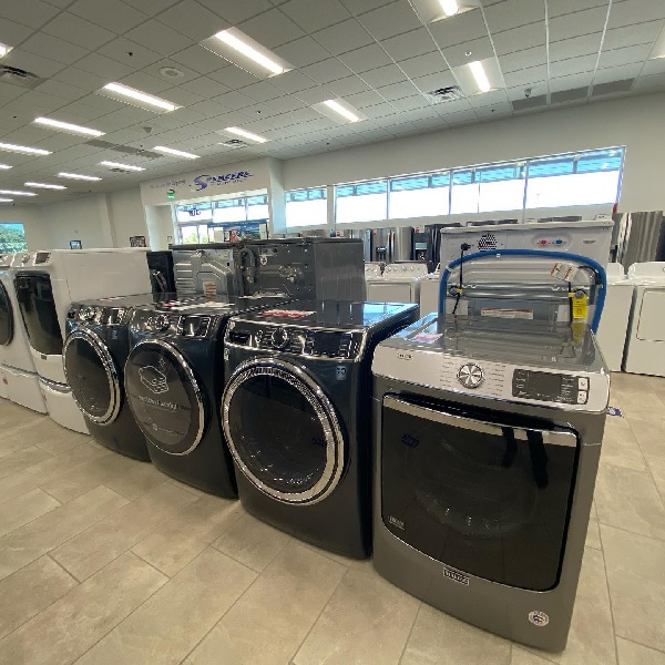 A variety of laundry appliances on a Spencer’s TV & Appliance showroom floor 