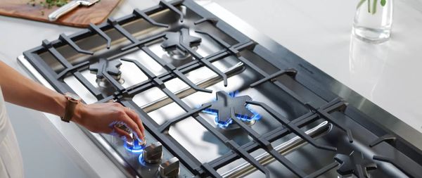 Person igniting a Pedestal Star Burner on a Thermador gas cooktop 
