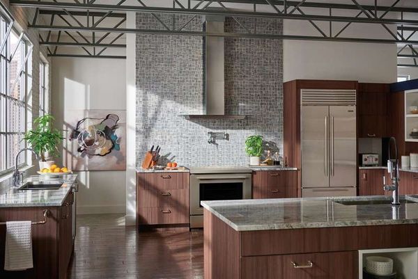 Modern kitchen outfitted with luxury stainless steel appliances and long marble countertops. 