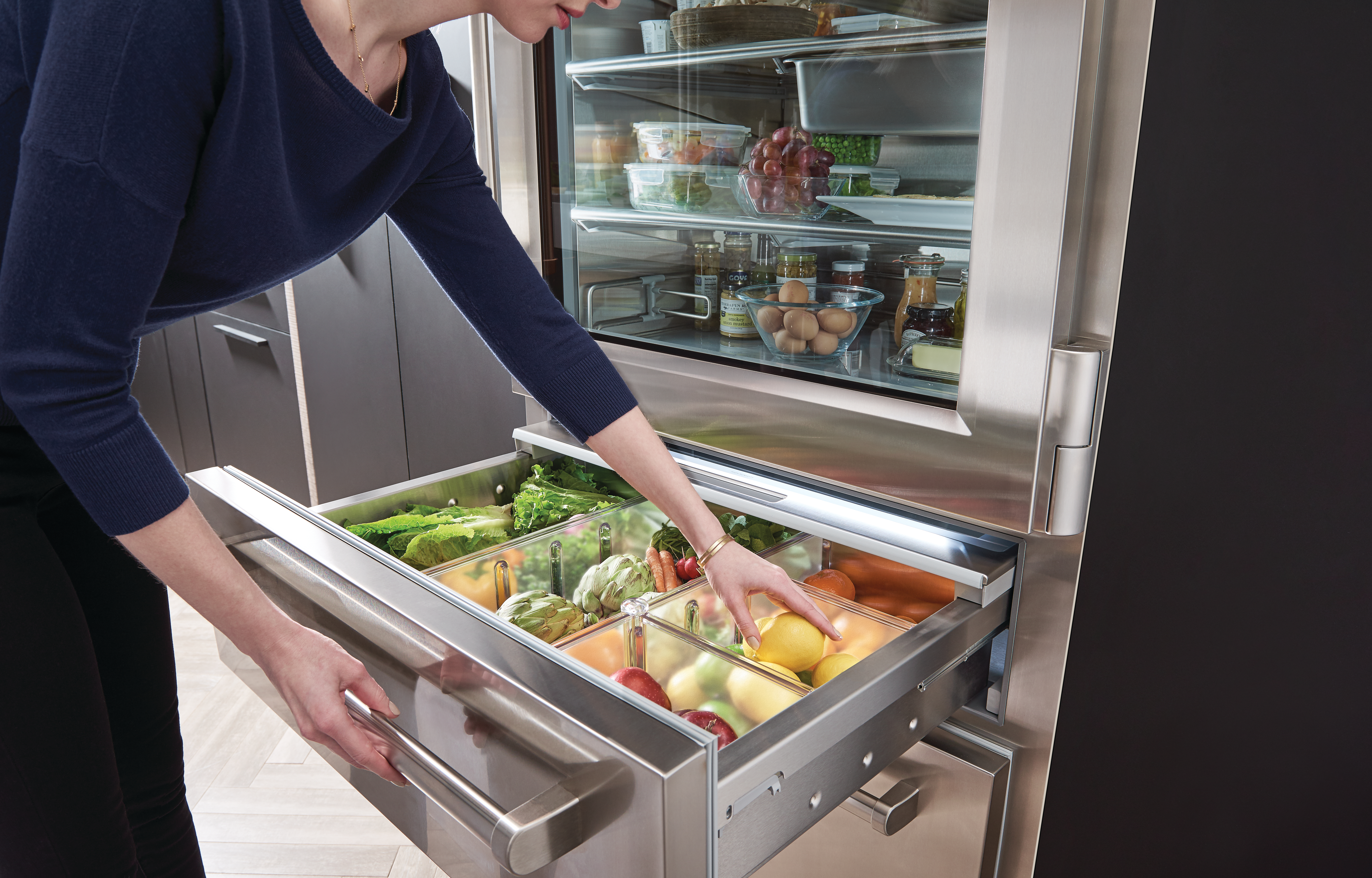 woman opens freezer drawer of Sub Zero pro-style refrigerator 