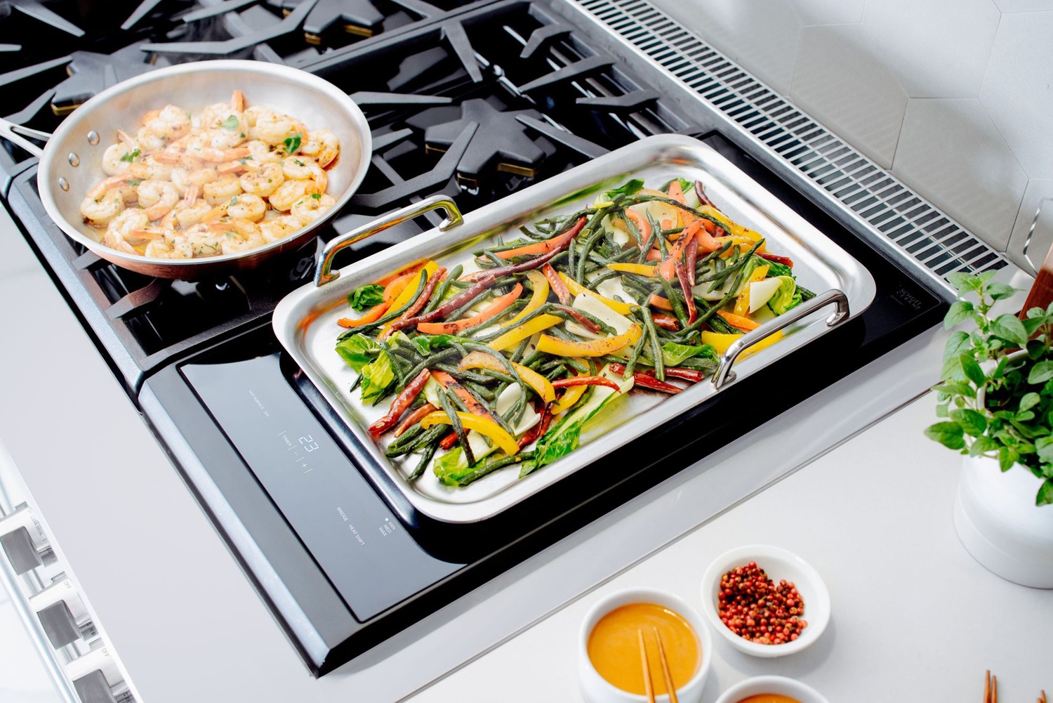 skillets of cooked peppers and shrimp on Thermador gas grates