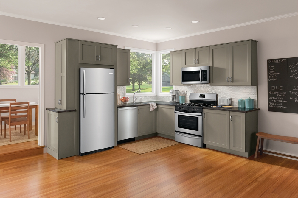 Frigidaire top freezer refrigerator in a typical American kitchen with other stainless steel appliances