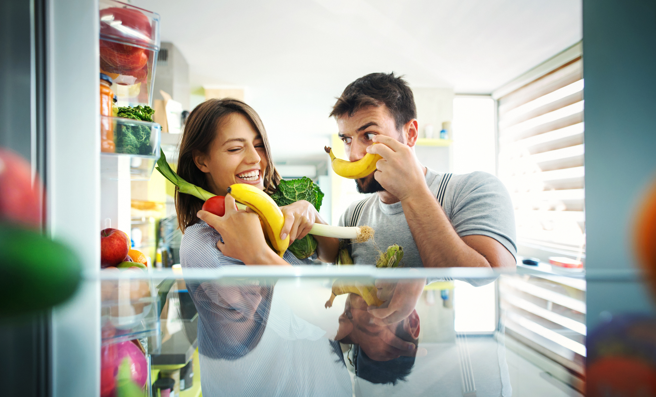 Couple using their top freezer fridge