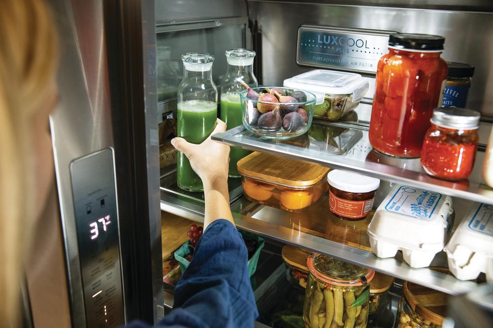 woman organizes the contents of her Electrolux French door refrigerator