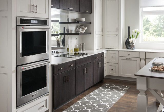 view of a modern kitchen with white and black cabinets, and a double wall oven in the front